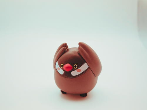 文鳥のオモチャが両羽を上に上げている写真