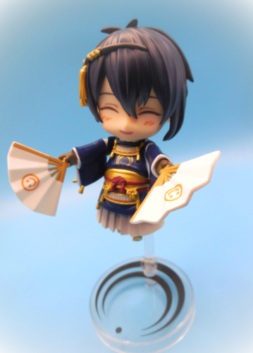 刀剣乱舞の三日月宗近ねんどろいど写真。両手にグッドスマイルカンパニーのマークが入った扇子を持って笑っている。