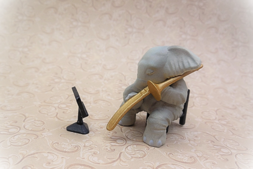 像が椅子に座って楽譜を見ながら楽器を演奏している