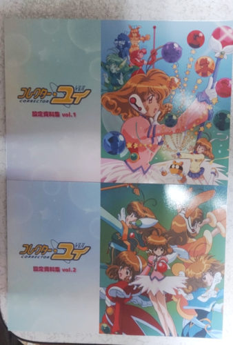 コレクター・ユイの設定資料集の写真。1と2が並んでいる。